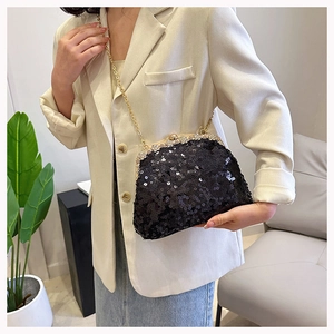 Detail of black sequin evening bag with sparkling rhinestones and golden chain strap