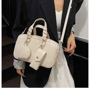 Detail of off-white pebble leather Boston bag featuring chic double mini pouch charms