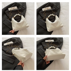 Detailed views of white crocodile pattern handbag with pearl handle and gold chain strap