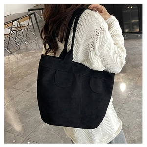 Détail du grand sac cabas noir montrant la texture suède et les surpiqûres en U