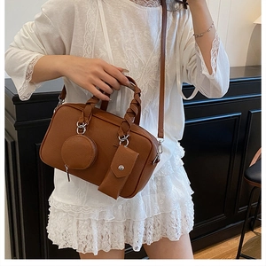 Brown lychee leather Boston bag featuring woven handles and stylish accessory pouches