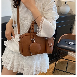 Close-up of brown lychee texture leather shoulder bag with a modular three-in-one design