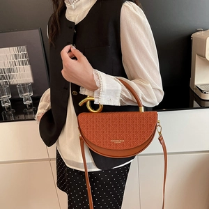 Brown half-moon saddle bag with woven texture, gold metal handle and leather strap