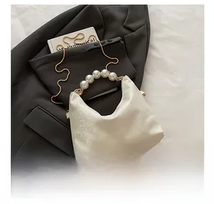 Detail of snake pattern leather bag with large pearl handle and gold chain strap