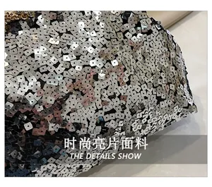 Macro detail of glittering silver sequins and laser-textured surface on the evening bag