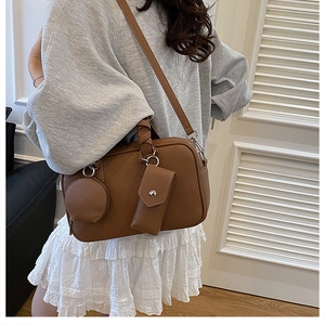 Brown lychee leather Boston bag with detachable accessory pouches worn cross-body