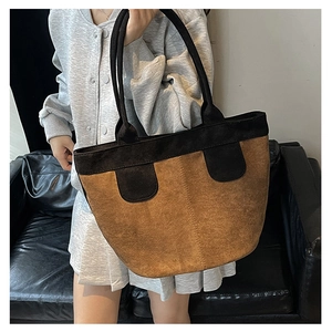 Détail du cabas vintage avec texture en daim marron et poignées contrastées noires
