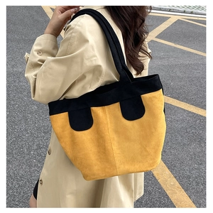 Vue latérale extérieure d'un grand sac cabas vintage jaune et noir avec larges bretelles