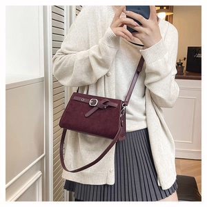 Détail du sac bandoulière bordeaux mat avec boucle en métal rétro et lanière en cuir