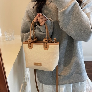 Grand sac cabas en paille tissée beige avec détails en cuir marron et anse nouée