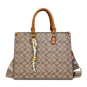 Classic brown monogram tote bag with wide strap and luxury woven tassel pendant