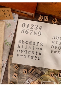 Nahaufnahme eines 70-teiligen Holzstempel-Sets mit Buchstaben und Zahlen auf Papier