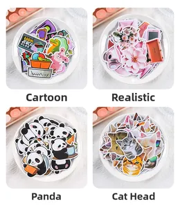 Close-up of cute panda and cat stickers in a ceramic dish on a pink workspace