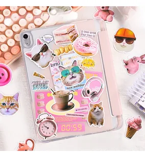 Close-up of cute cat and dessert stickers on a tablet case with a soft pink workspace