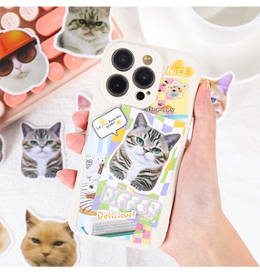 Detail of cute cat and dog stickers on a white iPhone case held over a pink keyboard