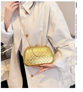 Detail of the golden woven clutch bag featuring a crystal lock and sleek metal chain strap