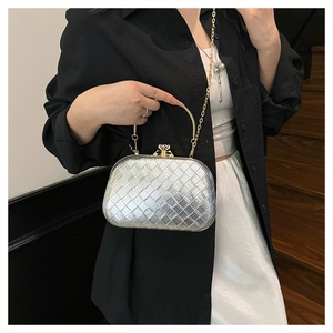 Close-up of silver woven texture evening clutch with gold metal clasp and chain strap
