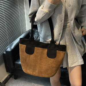 Grand sac cabas minimaliste en daim marron avec anses noires en situation décontractée
