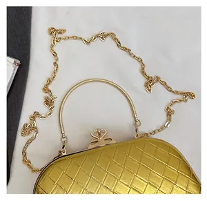 Close-up of golden woven texture evening bag with rhinestone clasp and metal handle