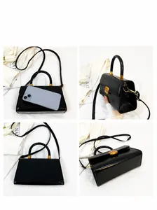 Detalles de bolso de cuero encerado negro con cierre dorado y asa redonda elegante