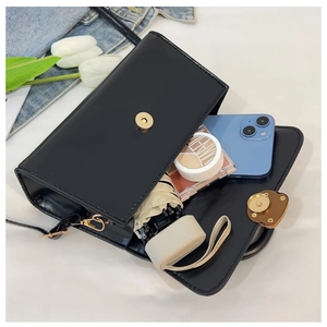 Detalle de bolso de cuero vintage negro con gran capacidad para artículos cotidianos