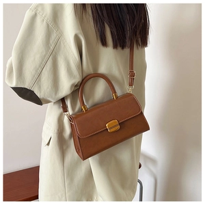 Vista lateral del bolso bandolera de cuero encerado vintage marrón con cierre dorado