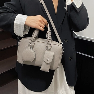 Grey Boston bowling bag with textured leather and round coin purse charm on crossbody strap