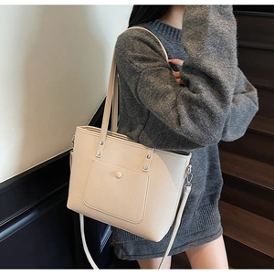Detail showing beige lychee textured tote bag with front snap pocket and adjustable strap