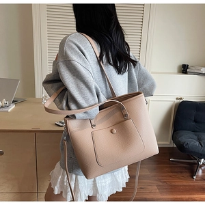 Detail of beige pebbled leather tote bag with front snap pocket and silver hardware detail