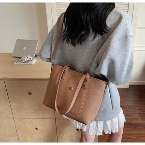 Close-up of brown litchi pattern leather tote bag with elegant magnetic pocket and strap