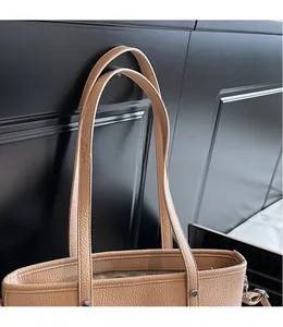 Detail der beigen Tote Bag aus Leder mit Litschi-Muster, glatten Trägern und Nieten