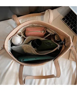 Innenansicht der beigen Shopper-Tasche mit Kieselmaserung und großem Stauraum für Utensilien