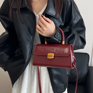 Bolso bandolera vintage de cuero brillante burdeos con hebilla dorada en modelo