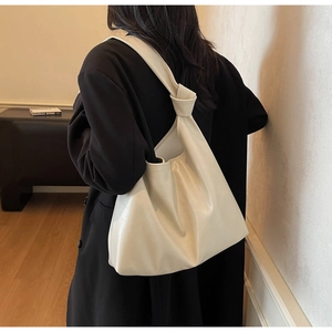 Minimalist beige tote bag with a soft knotted handle design for casual shoulder carry