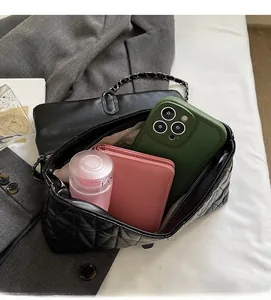 Interior view of black quilted chain bag showing large capacity for phone and wallet