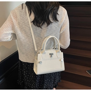 Close-up of cream lychee texture crossbody bag with silver hardware and adjustable strap