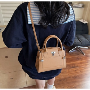 Lifestyle view of camel lychee pattern handbag with silver lock and adjustable strap
