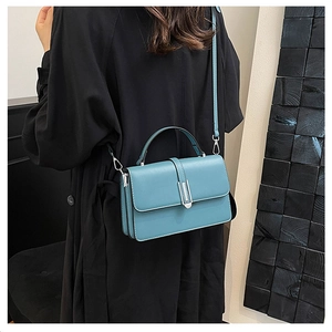 Detail of blue PU leather shoulder bag with silver metal buckle and adjustable strap