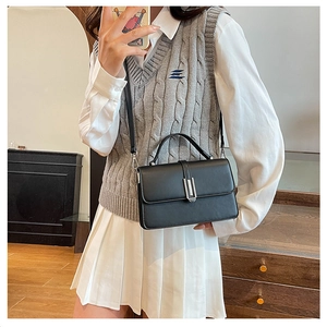 Classic black square handbag with silver metal buckle and detachable strap shown on model