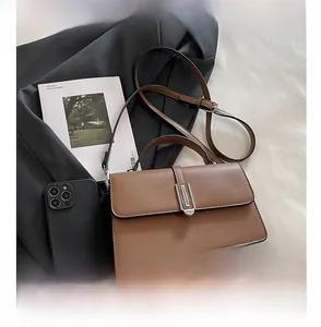 Detail of classic brown leather crossbody bag with elegant silver rectangular metal lock