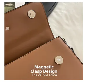 Detail view of the brown leather handbag featuring dual magnetic snap button closures