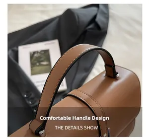 Close-up of brown leather handbag handle with silver hardware and precise stitching details