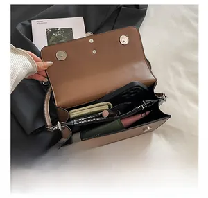 Detailed view of brown leather crossbody bag interior showing spacious compartments and storage