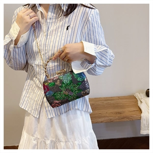 Detail der floralen Pailletten-Abendtasche mit Knoten-Griff und goldener Kette