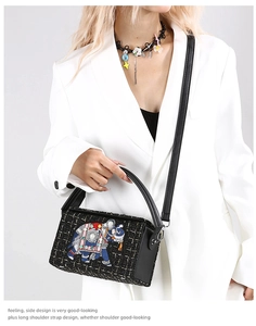 Detailed embroidery on a black tweed bag featuring a pearl elephant pattern and strap