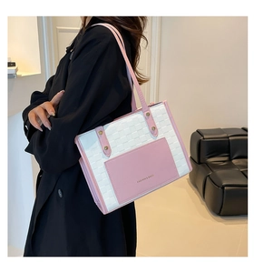 Détail du sac cabas tissé avec poche avant rose et finitions métalliques dorées