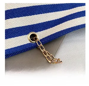 Detail of blue and white twill fabric with gold eyelets and premium metal chain strap