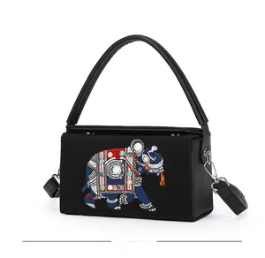 Side view of ethnic elephant embroidery and beadwork detail on black crossbody bag