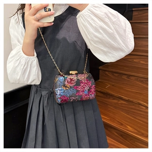 Detailaufnahme der Pailletten-Abendtasche mit bunten Blumenmustern und Goldverzierung