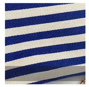 Close-up of blue and white striped canvas fabric with herringbone weave and gold hook